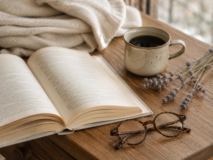 Open hardback novel with mug and lavender